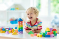 Kids toys. Child building tower of toy blocks.