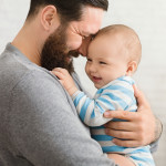 Loving father embracing his cute baby son