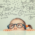 beautiful cute little girl with math formulas and problems