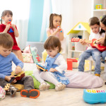 Kindergarten teacher with children on music lesson in daycare. Little kids toddlers play together with musical toys.